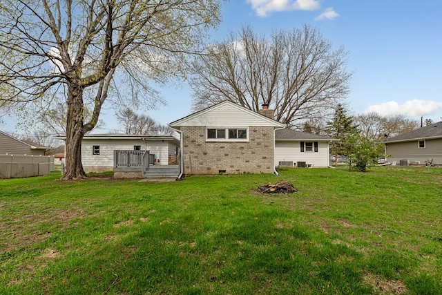 back of house featuring a yard, brick siding, fence, crawl space, and a wooden deck