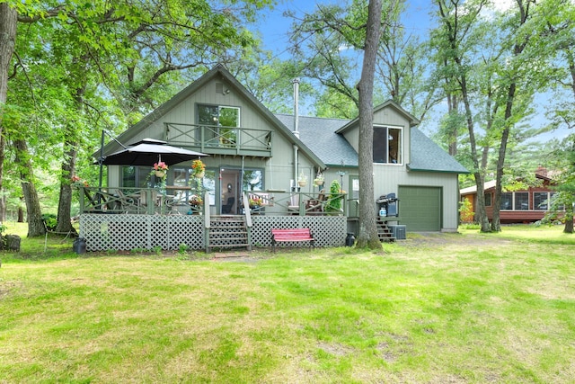 rear view of house with a lawn, a wooden deck, driveway, and a shingled roof