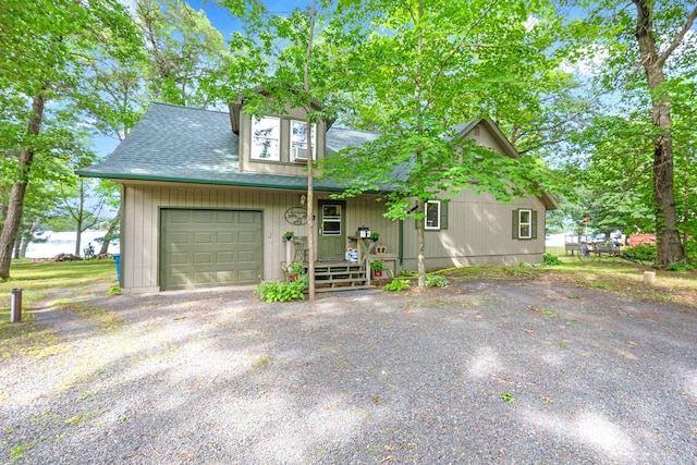 rustic home with a porch, a shingled roof, driveway, and a garage