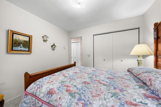 bedroom featuring baseboards, carpet floors, and a textured ceiling