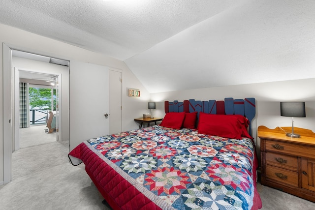 bedroom featuring vaulted ceiling, carpet, and a textured ceiling