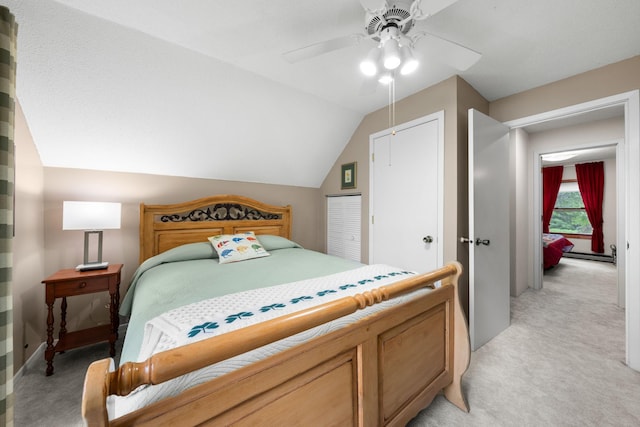 bedroom with lofted ceiling, ceiling fan, a closet, and light colored carpet