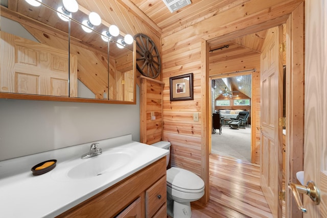 bathroom featuring toilet, wood finished floors, wooden ceiling, wood walls, and visible vents