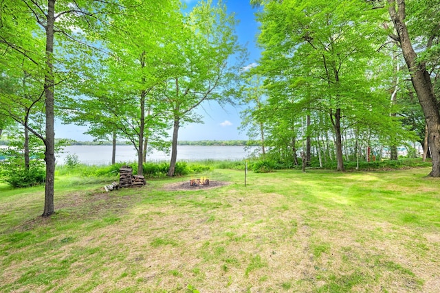 view of yard with a fire pit and a water view