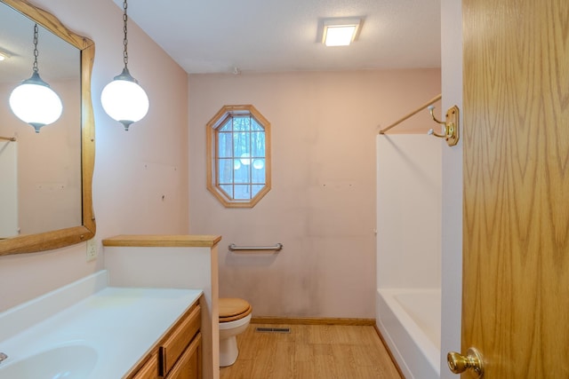full bath featuring visible vents, wood finished floors, shower / washtub combination, vanity, and toilet