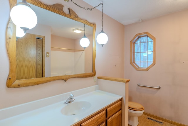bathroom with vanity, baseboards, toilet, and visible vents
