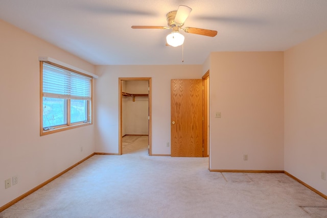 unfurnished bedroom with a ceiling fan, baseboards, light carpet, and a closet