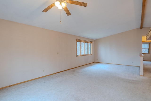 spare room with plenty of natural light, baseboards, and light carpet
