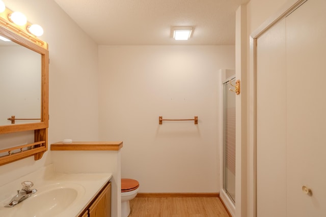 full bath with vanity, wood finished floors, toilet, and a shower stall