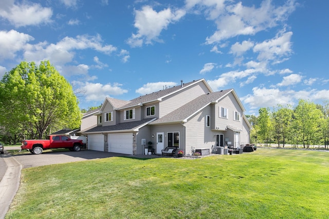 3831 232nd Ave NW Unit 105, Saint Francis, MN 55070 - view of property exterior featuring asphalt driveway, roof with shingles, a lawn, and a garage