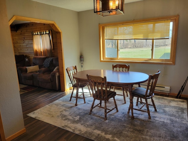 dining space with baseboard heating, baseboards, and wood finished floors