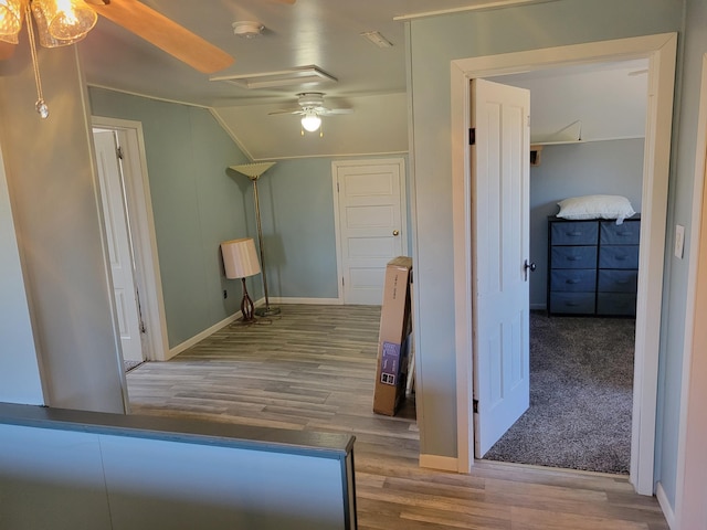 interior space featuring vaulted ceiling, wood finished floors, and baseboards