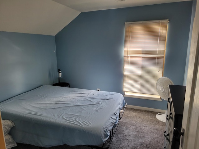 carpeted bedroom with lofted ceiling and baseboards