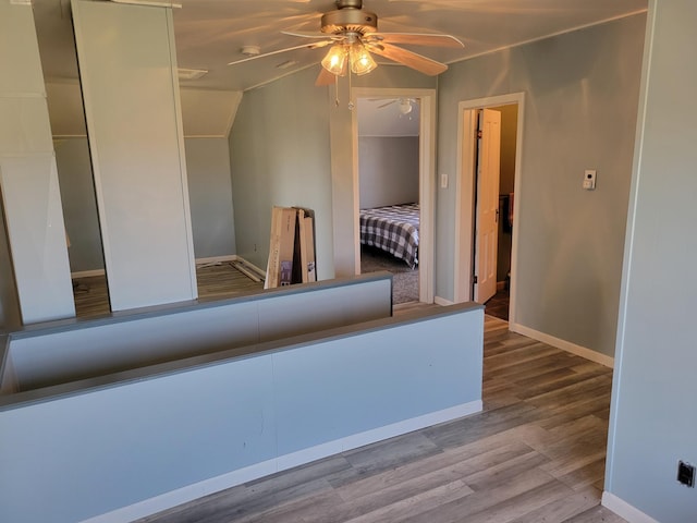 unfurnished bedroom featuring baseboards, vaulted ceiling, and wood finished floors