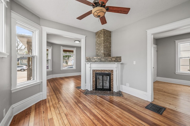 1527 Minnehaha Ave W, Saint Paul, MN 55104 - unfurnished living room featuring visible vents, light wood-type flooring, ceiling fan, and a brick fireplace