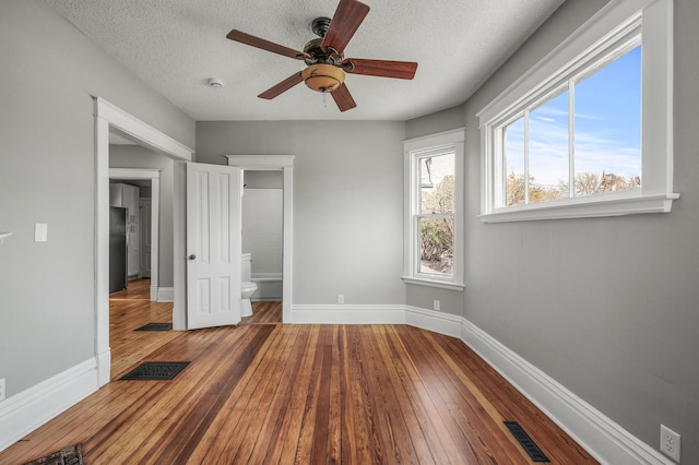 1527 Minnehaha Ave W, Saint Paul, MN 55104 - unfurnished bedroom featuring baseboards, visible vents, hardwood / wood-style flooring, and a textured ceiling
