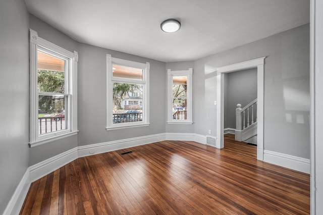 1527 Minnehaha Ave W, Saint Paul, MN 55104 - unfurnished room featuring baseboards, stairway, visible vents, and dark wood-type flooring
