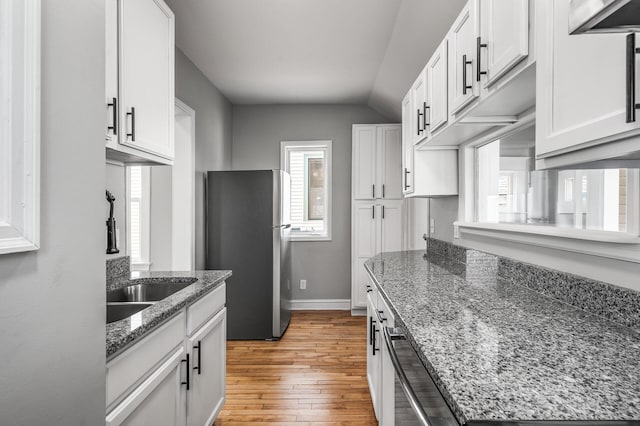 1527 Minnehaha Ave W, Saint Paul, MN 55104 - kitchen featuring a sink, light wood-style floors, white cabinetry, dishwasher, and freestanding refrigerator