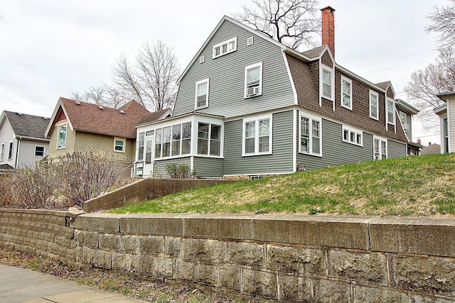 717 3rd St, Red Wing, MN 55066 - back of house featuring a chimney, a gambrel roof, a sunroom, and a shingled roof