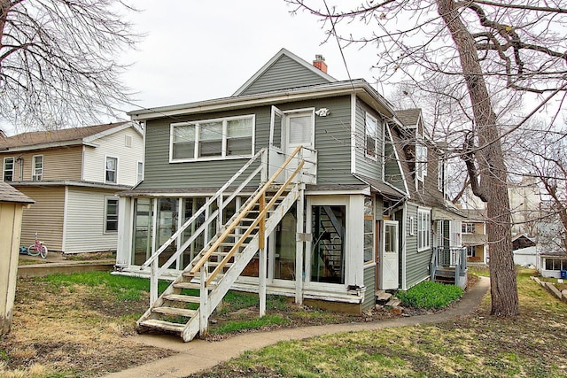 717 3rd St, Red Wing, MN 55066 - back of house with a chimney, stairway, and a sunroom