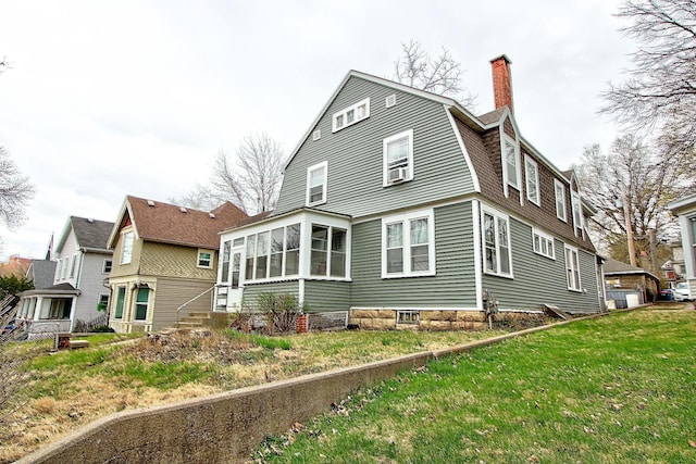 717 3rd St, Red Wing, MN 55066 - back of property with a gambrel roof, a chimney, and a sunroom