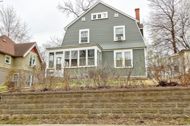 717 3rd St, Red Wing, MN 55066 - back of property with a chimney, a gambrel roof, and a sunroom