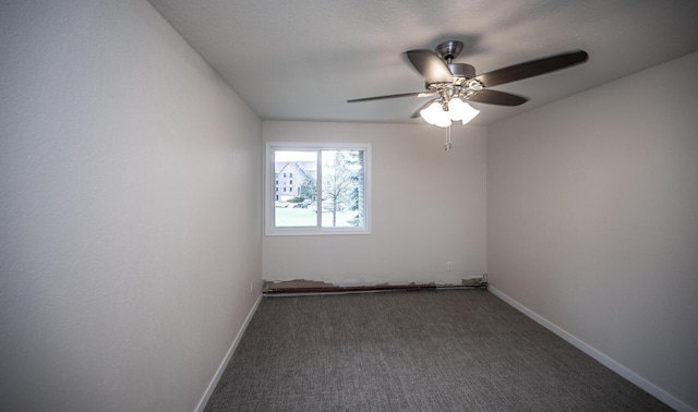 carpeted spare room with a ceiling fan and baseboards