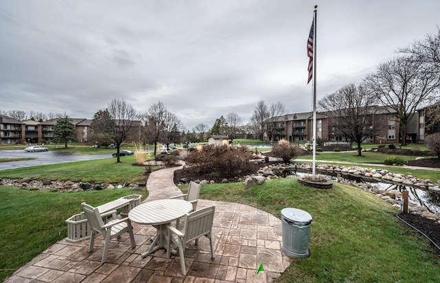 view of community featuring a lawn and a patio