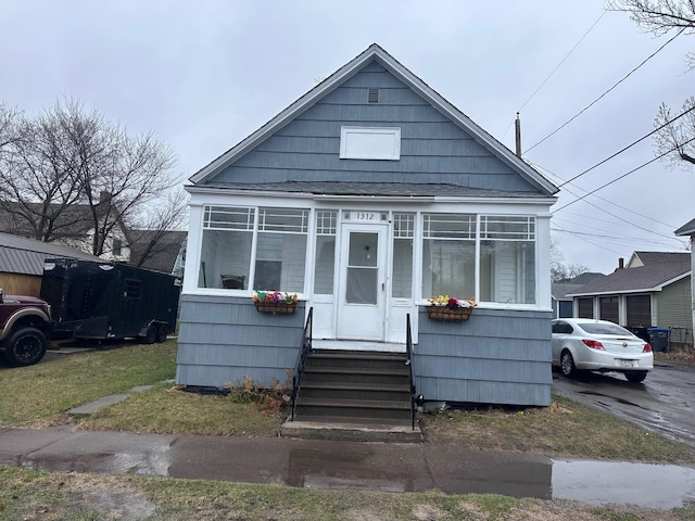bungalow-style house featuring roof with shingles and entry steps