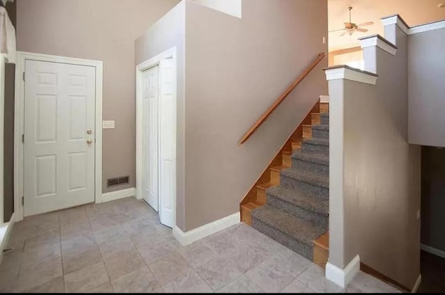 stairway with visible vents, baseboards, and ceiling fan
