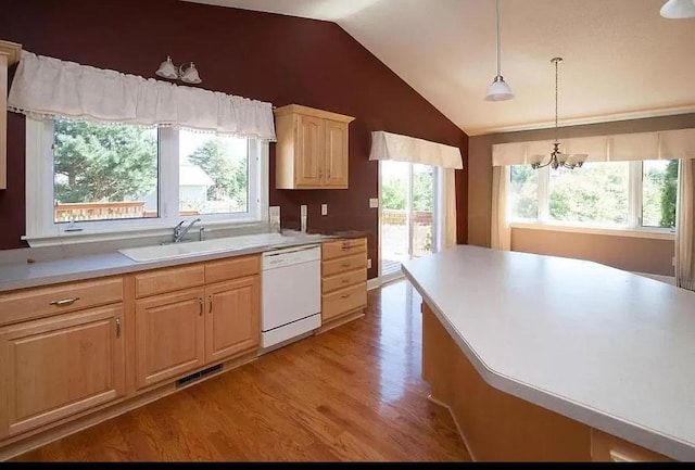 kitchen with an inviting chandelier, vaulted ceiling, dishwasher, light brown cabinets, and light wood-type flooring