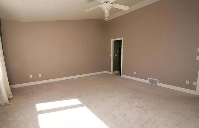 spare room featuring baseboards, visible vents, carpet, lofted ceiling, and ceiling fan
