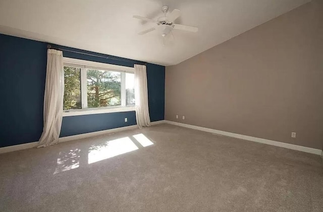 unfurnished room featuring lofted ceiling, carpet flooring, baseboards, and a ceiling fan