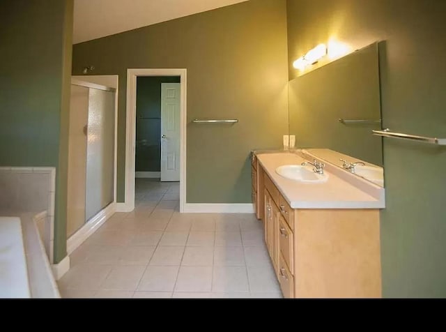 full bathroom featuring a shower stall, vaulted ceiling, tile patterned floors, vanity, and baseboards
