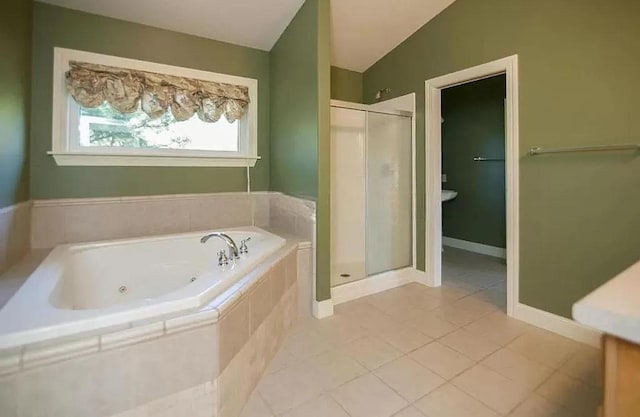 bathroom with tile patterned floors, vaulted ceiling, baseboards, a whirlpool tub, and a shower stall