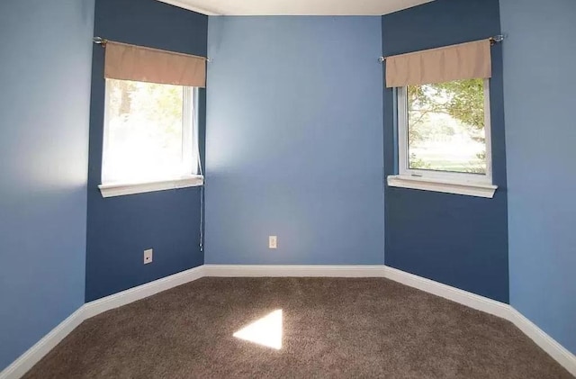 spare room featuring carpet floors and baseboards