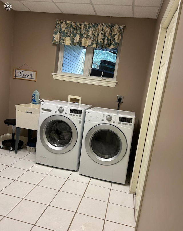laundry room with washing machine and dryer, baseboards, laundry area, and light tile patterned flooring