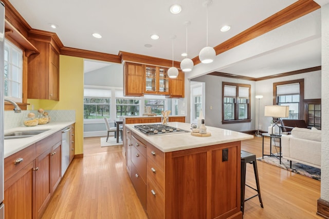 2736 Chowen Ave S, Minneapolis, MN 55416 - kitchen with a kitchen island, appliances with stainless steel finishes, a sink, light wood-style floors, and ornamental molding