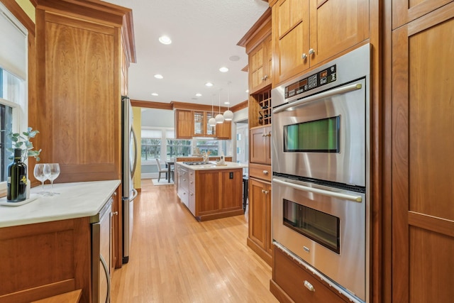 2736 Chowen Ave S, Minneapolis, MN 55416 - kitchen with brown cabinetry, wine cooler, an island with sink, light wood-style flooring, and appliances with stainless steel finishes