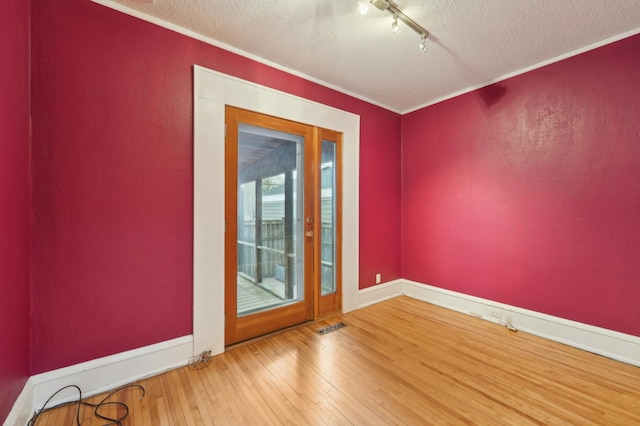 2736 Chowen Ave S, Minneapolis, MN 55416 - empty room with visible vents, crown molding, track lighting, wood-type flooring, and a textured ceiling