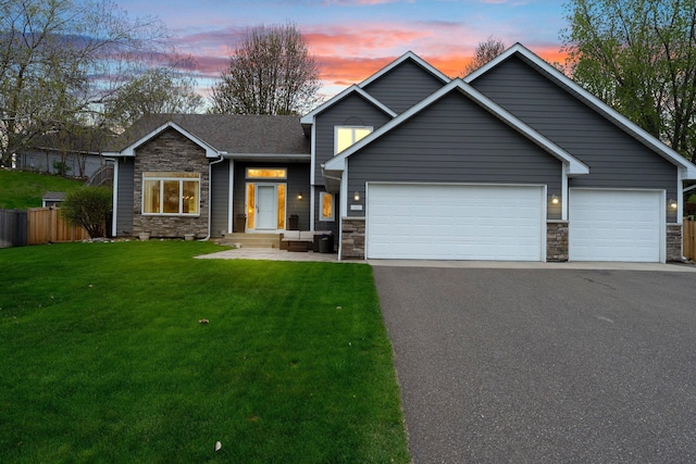 craftsman-style home with stone siding, aphalt driveway, a front yard, and fence