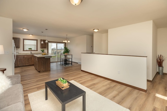 231 Julia St, Claremont, MN 55924 - living area with baseboards, a notable chandelier, light wood-style floors, and visible vents