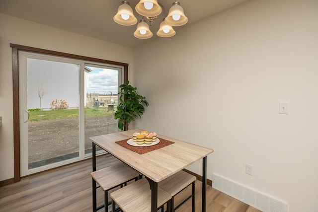 231 Julia St, Claremont, MN 55924 - dining room with light wood-type flooring, visible vents, baseboards, and a notable chandelier