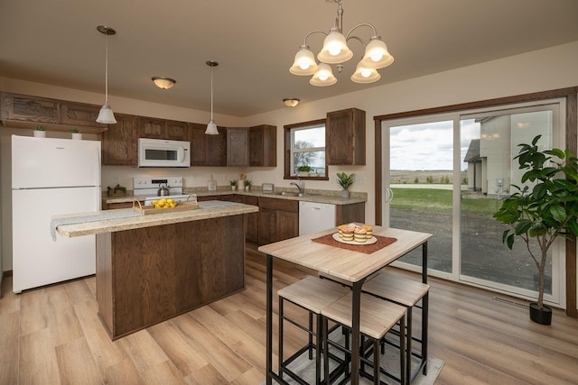 231 Julia St, Claremont, MN 55924 - kitchen with a center island, a sink, white appliances, dark brown cabinetry, and decorative light fixtures