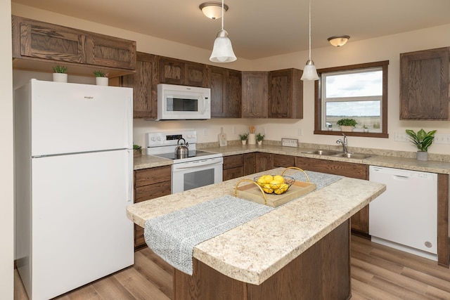 231 Julia St, Claremont, MN 55924 - kitchen featuring light countertops, a sink, white appliances, light wood-style floors, and hanging light fixtures