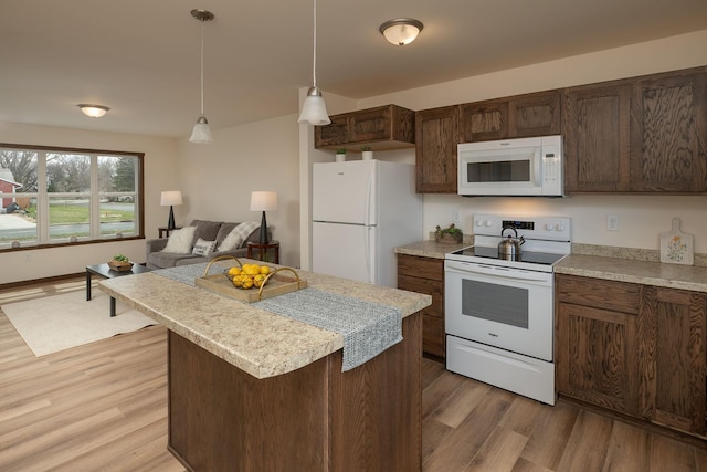 231 Julia St, Claremont, MN 55924 - kitchen with light countertops, white appliances, decorative light fixtures, a center island, and light wood-style flooring