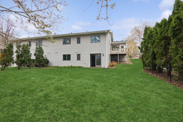 back of house featuring a lawn and a wooden deck