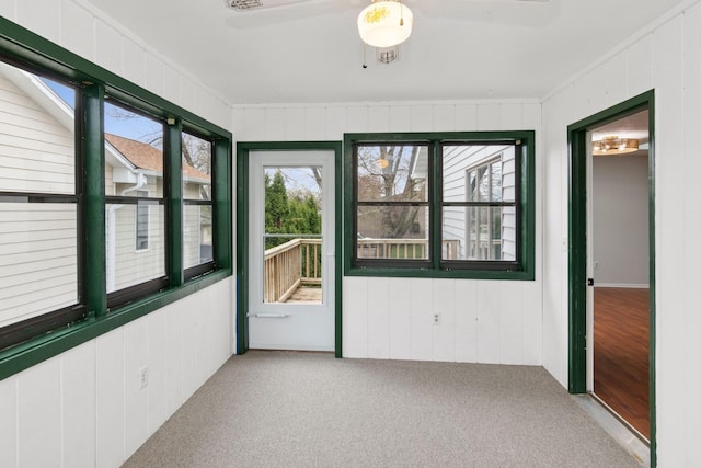unfurnished sunroom with ceiling fan