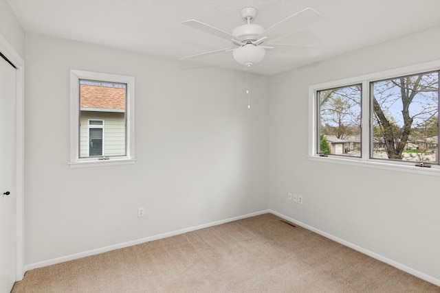 empty room featuring baseboards and light colored carpet