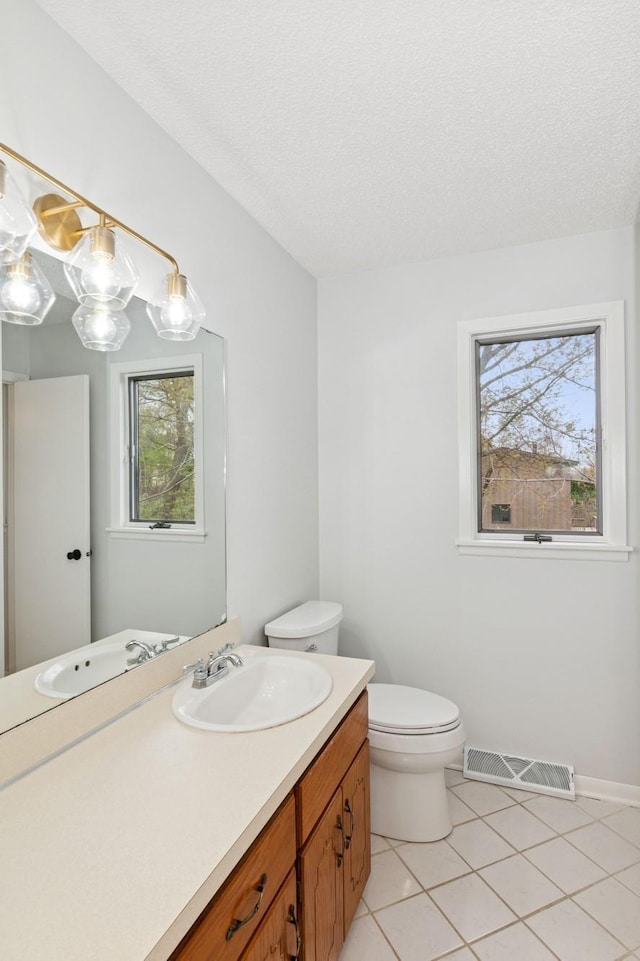 bathroom featuring toilet, visible vents, plenty of natural light, and tile patterned flooring
